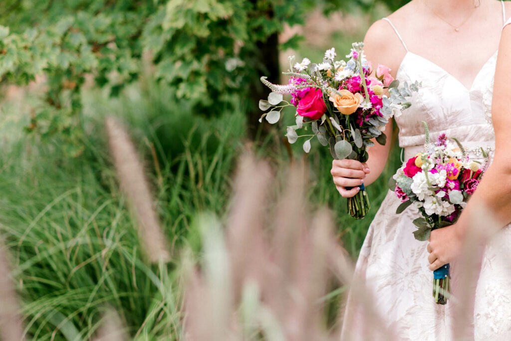 brides holding pink floral bouquets