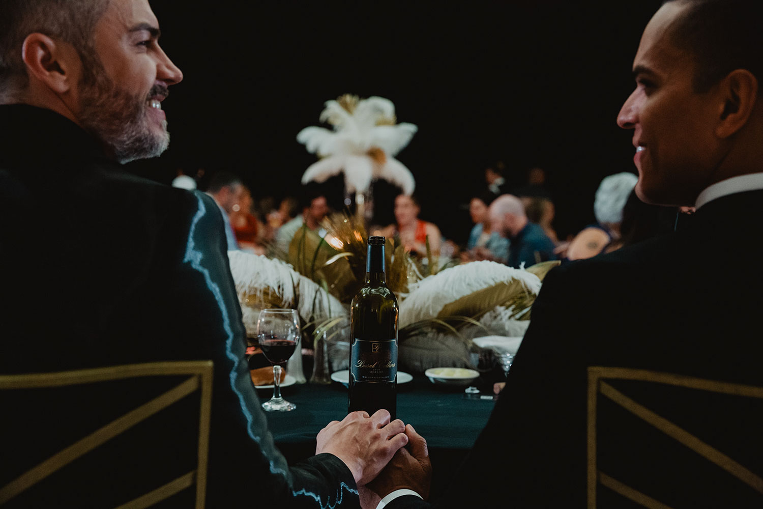 grooms sitting at sweetheart table at their luxury wedding