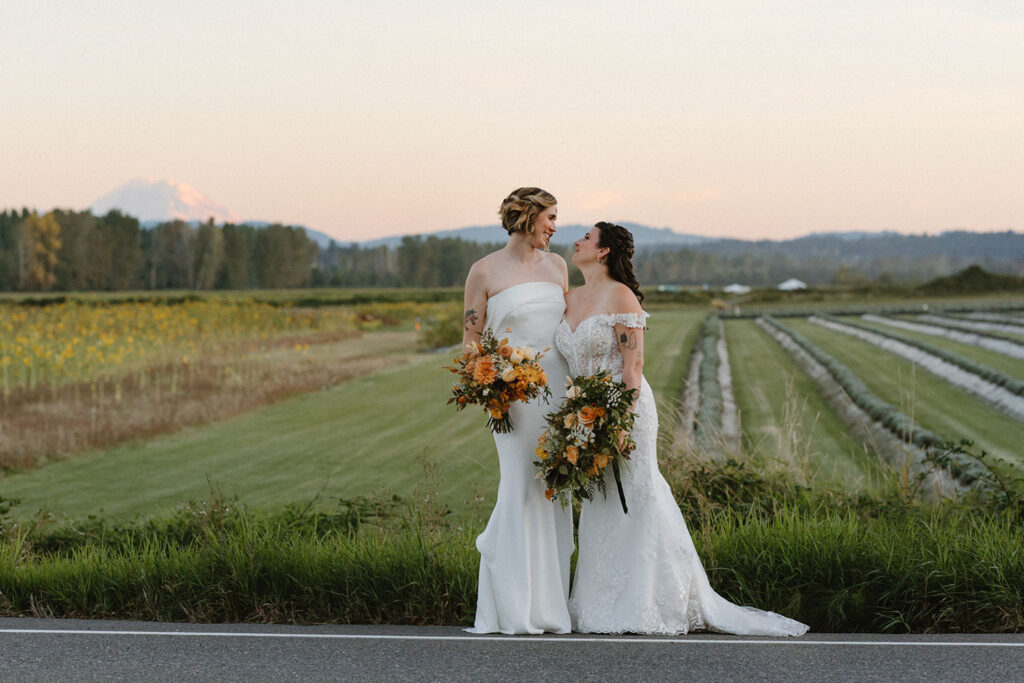 Steph and Lauren standing in front of a field at their wedding in Seattle