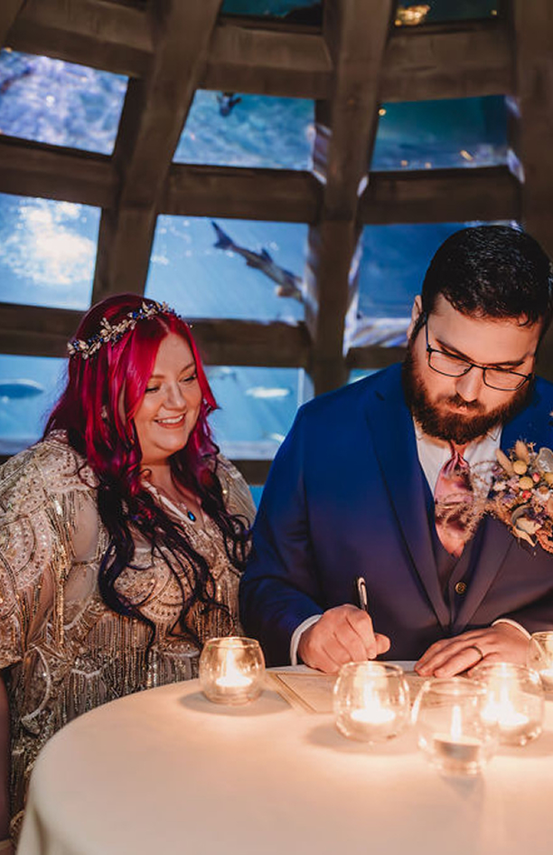 bride and groom signing marriage certificate at Seattle aquarium