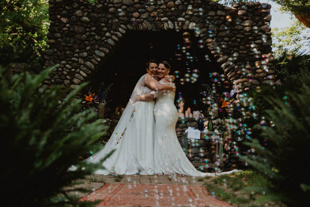 two brides hugging on wedding day