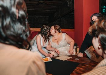 two brides kiss after signing marriage license at Georgetown Ballroom wedding