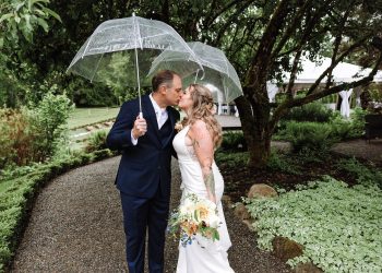 bride and groom kissing under clear umbrellas at wedding in seattle