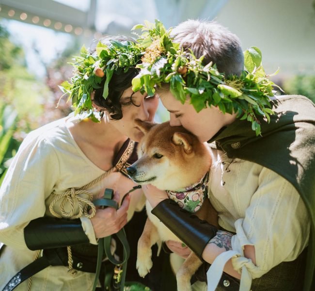 Sid and Ren snuggling their dog on their wedding day