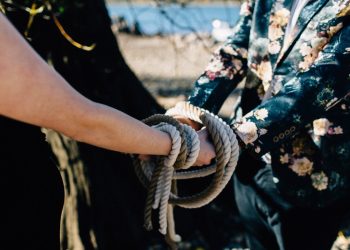 handfasting cords tied around couple during wedding ceremony