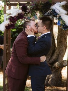 Two grooms kiss at Seattle backyard wedding